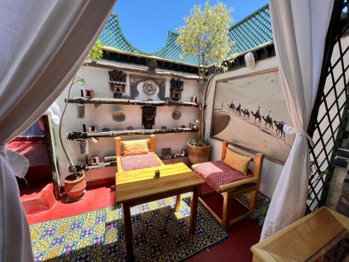 einen kleinen Balkon mit einem Tisch und 2 Stühlen in der Unterkunft Dar Belmamoun in Fès