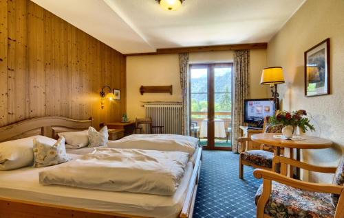 um quarto de hotel com duas camas e uma televisão em Hotel Georgenhof em Schönau am Königssee