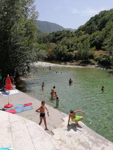a group of people in the water at a beach at Motel and Restaurant Odušak in Drežnjak