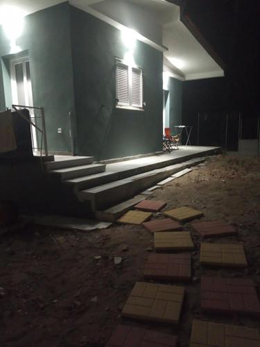 a building with stairs and a window at night at Διαμέρισμα κοντά στην θάλασσα in Arkoudi