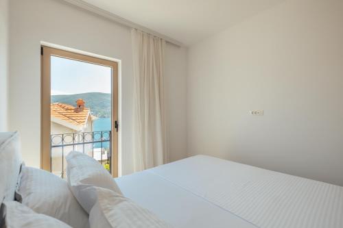 a bedroom with a bed and a large mirror at Boka Apartment 6 in Herceg-Novi