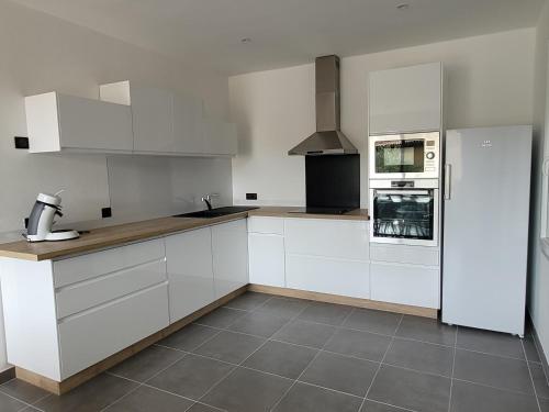  La cuisine est équipée de placards blancs et d'un réfrigérateur. dans l'établissement L'Oustau de Laëtitia Animaux bienvenus, à Fontaine-de-Vaucluse