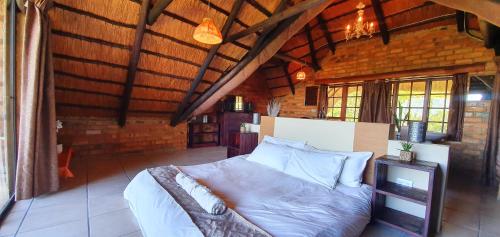 a bedroom with a bed in a room with wooden ceilings at Wide Horizons Mountain Retreat in Malkerns