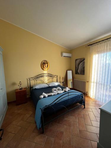 a bedroom with a bed with a blue comforter at Villetta Vista Mare Cornino in Custonaci