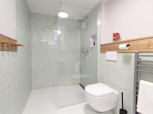 y baño blanco con aseo y ducha. en Baron Apartments Sušice en Sušice