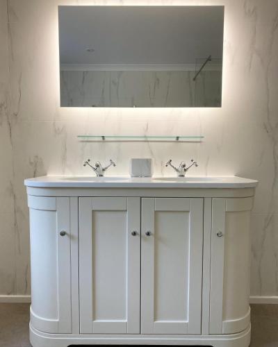 a bathroom with a white sink and a mirror at Holyland House - Greenacres Estates in Pembrokeshire