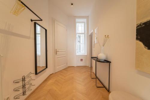 korytarz z lustrem i wazą na stole w obiekcie josef's home I Deluxe Apartment in Ideal Location w Wiedniu
