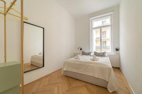sypialnia z łóżkiem i lustrem w obiekcie josef's home I Deluxe Apartment in Ideal Location w Wiedniu