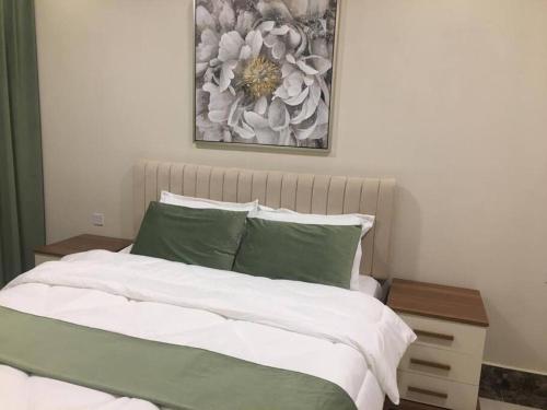 a bedroom with a bed and a picture on the wall at Lovely Beach Apartment in Salalah