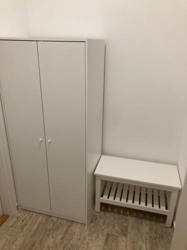 a white cabinet and a white bench in a room at Bólyi Panzió in Bóly