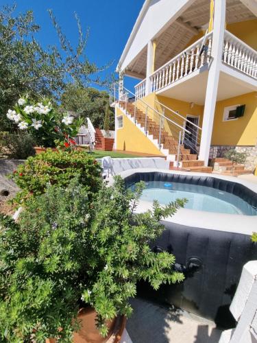 a house with a swimming pool in front of a house at Apartmani Axa in Rukavac