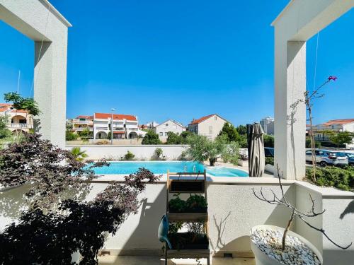 a view of a swimming pool from the balcony of a house at Apartments and Rooms Mateša in Vodice