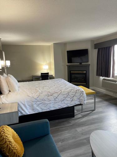 a hotel room with a bed and a fireplace at HomeTown Inn and Suites Belle Plaine in Belle Plaine