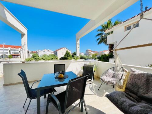 a patio with a blue table and chairs at Apartments and Rooms Mateša in Vodice
