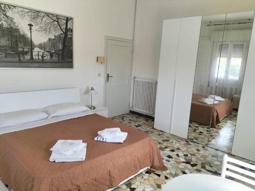 een slaapkamer met een bed met handdoeken erop bij Affittacamere Mark in Faenza