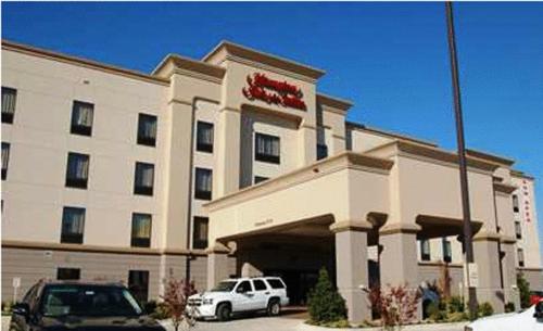 a hotel with cars parked in front of it at Hampton Inn & Suites McAlester in McAlester