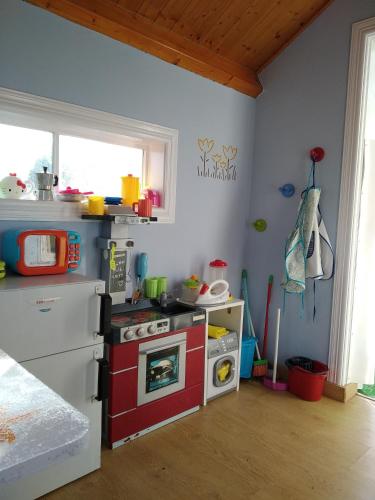 a toy kitchen with a red and white stove at Apartamentos La Cruz de Paderne in Navia