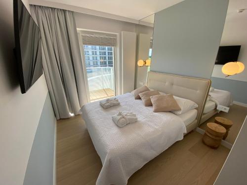 a bedroom with a white bed with towels on it at Polanki Aqua Apartament LUNA in Kołobrzeg