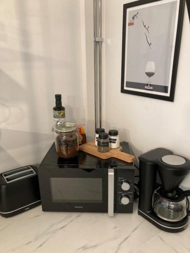 eine schwarze Mikrowelle auf einer Küchentheke mit Mixer in der Unterkunft Hurmaava vierassviitti hyvällä sijainnilla! in Naantali