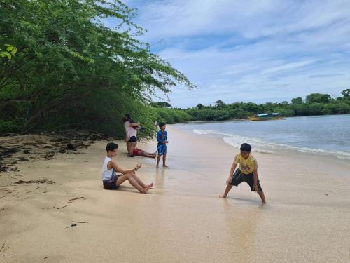 eine Gruppe Kinder, die am Strand spielen in der Unterkunft Calatagan's Bahay Kubo - with Beach Access in Batangas City