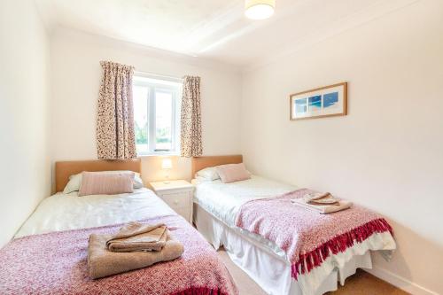 a bedroom with two beds and a window at Springfield Cottage in Chipping