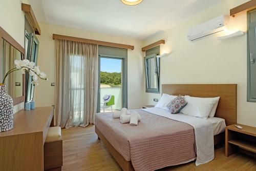 una camera d'albergo con un letto e una grande finestra di Villa Paleos Evergreen by Villa Plus a Ialyssos