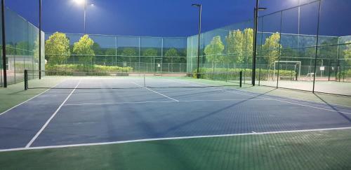 a tennis court with two tennis rackets on it at BSP21 Family Homestay in Jenjarum