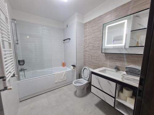 a bathroom with a tub and a toilet and a sink at Ghencea Residence 158 L1 in Bucharest
