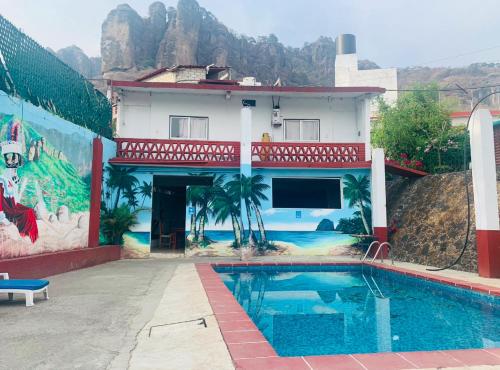 a house with a swimming pool in front of a building at Hotel Puerto Villamar in Tepoztlán