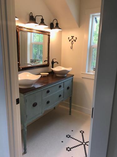 a bathroom with two sinks and a mirror at Snowgoose Pond Bed & Breakfast in Palmer