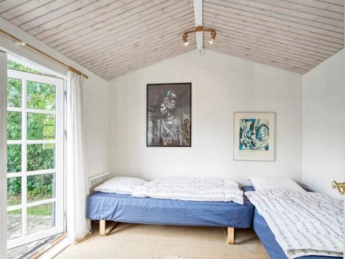 2 Betten in einem Zimmer mit Fenster in der Unterkunft Holiday home Helsinge in Helsinge
