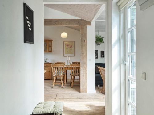 Holiday home Helsinge في Helsinge: ممر يؤدي إلى غرفة طعام ومطبخ مع طاولة