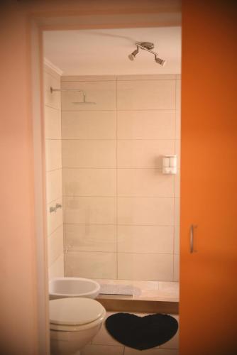 a bathroom with a toilet and a sink and a shower at Nice Alem in Tandil