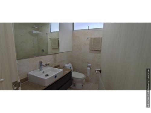 uma casa de banho com um lavatório, um WC e um espelho. em Santa Marta Apartamento en Bello Horizonte em Santa Marta