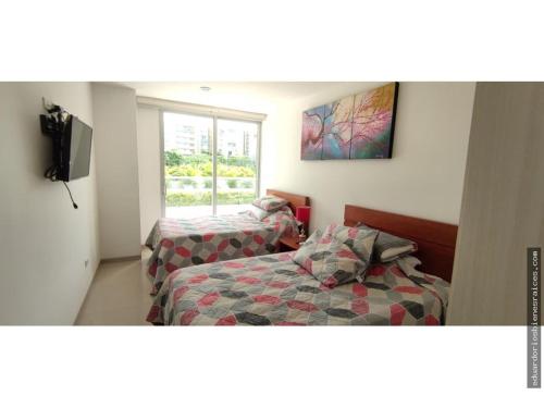 1 dormitorio con 2 camas, TV y ventana en Santa Marta Apartamento en Bello Horizonte, en Santa Marta