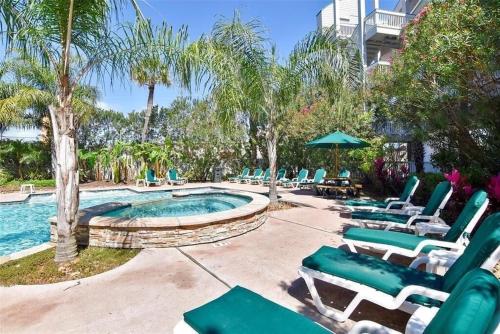 una piscina con sedie a sdraio e una piscina di Sun Splashed Condo! Steps to Beach and 2 Pools Galveston Island a Galveston