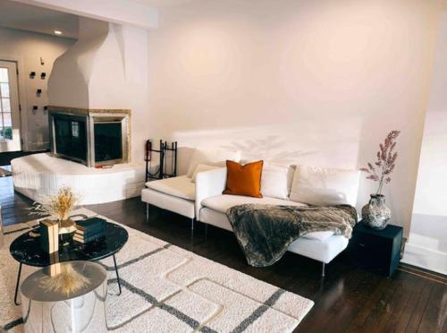 uma sala de estar com um sofá branco e uma televisão em The 212 Escape em Saugerties