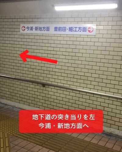 a red sign on a brick wall with a red arrow at BRIDGE Share House in Shimonoseki