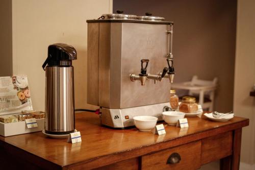 Hotel Gramado Interlaken في غرامادو: وجود ماكينة قهوة على طاولة خشبية