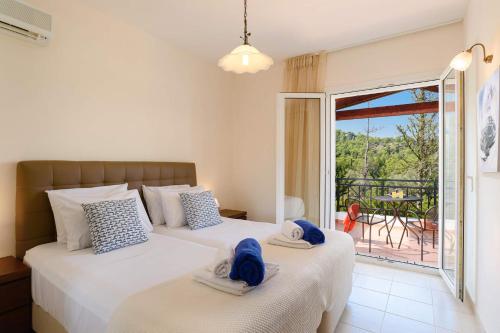 2 łóżka w sypialni z widokiem na balkon w obiekcie Villa Apollo Springs by Villa Plus w Kolymbii