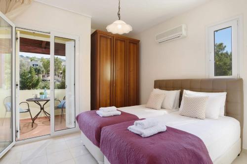 1 dormitorio con 2 camas y balcón en Villa Ermis Springs by Villa Plus, en Kolymbia