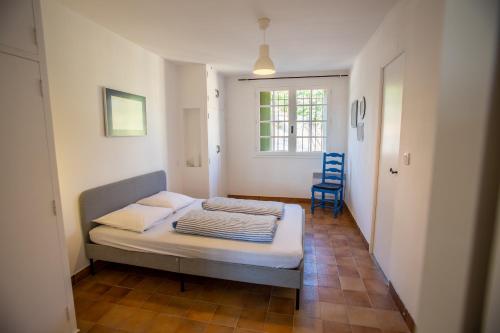 Habitación pequeña con cama y silla azul en Domaine Saint Laurent, en Béziers