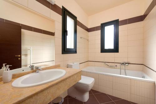 łazienka z umywalką, wanną i toaletą w obiekcie Villa Dimitra Springs by Villa Plus w Kolymbii
