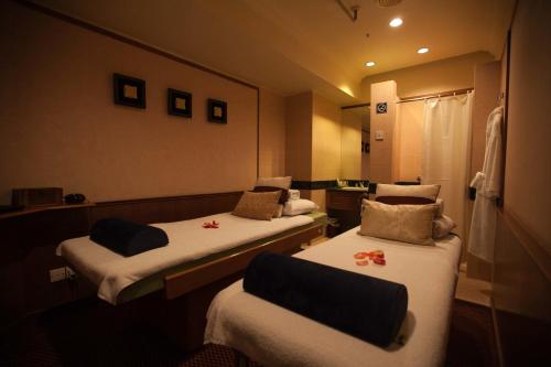 a hotel room with two beds and a mirror at JEN Penang Georgetown by Shangri-La in George Town