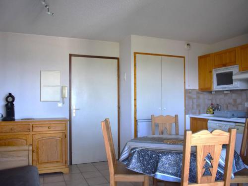 - une cuisine avec une table, une table et des chaises dans l'établissement Charmant 2 pièces plein sud avec balcon, proche centre-ville de Font-Romeu, parking et local à skis - FR-1-580-70, à Font-Romeu-Odeillo-Via