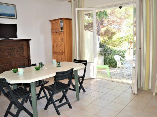 d'une salle à manger avec une table, des chaises et une porte coulissante en verre. dans l'établissement Appartement T2 pour 4 personnes, proche plage et commerces, jardin privé, parking, animaux acceptés - FR-1-226B-111, à Cavalaire-sur-Mer