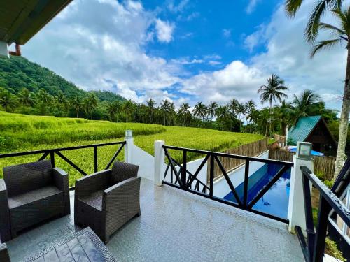 uma varanda de uma villa com cadeiras e uma piscina em A House Lucban Resort & Spa em Tayabas