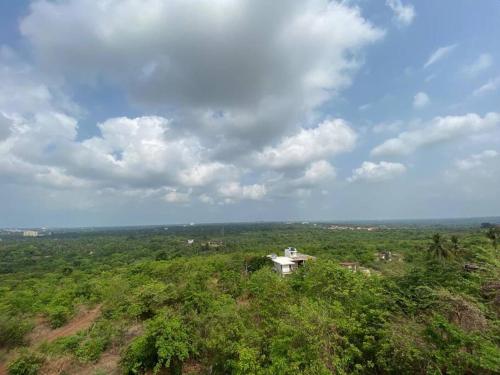 uma casa no topo de uma colina com árvores em AR Springfields(1), amidst lush green scenic view em Manipal
