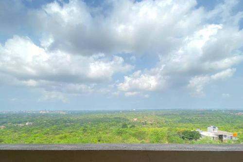 uma vista para um céu com nuvens e árvores em AR Springfields(1), amidst lush green scenic view em Manipal