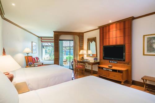 a bedroom with two beds and a flat screen tv at JW Marriott Phuket Resort and Spa in Mai Khao Beach